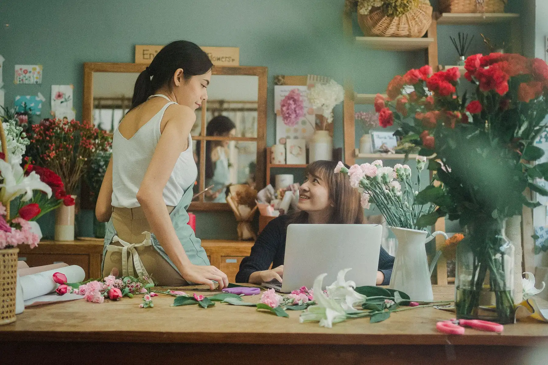 Two florists at a laptop in their shop