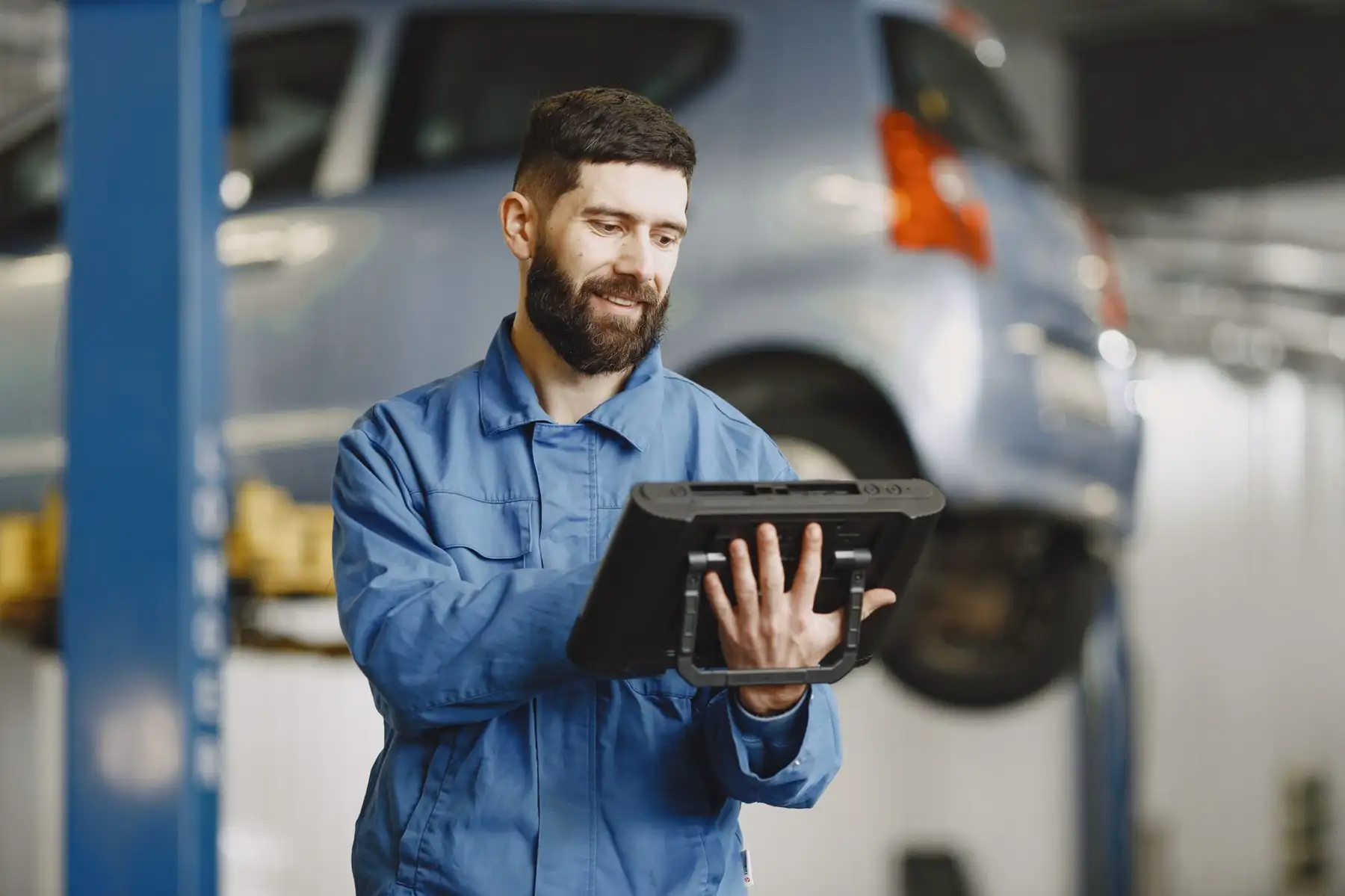 A mechanic checking a tablet in his garage